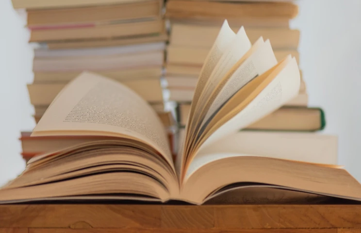 Livre ouvert devant une pile de livres